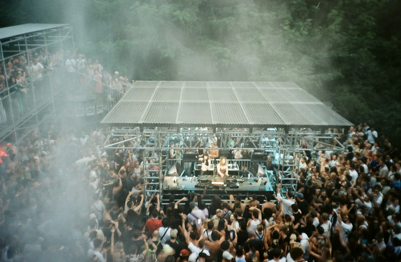 Crowd gathered around a DJ at an outdoor music event