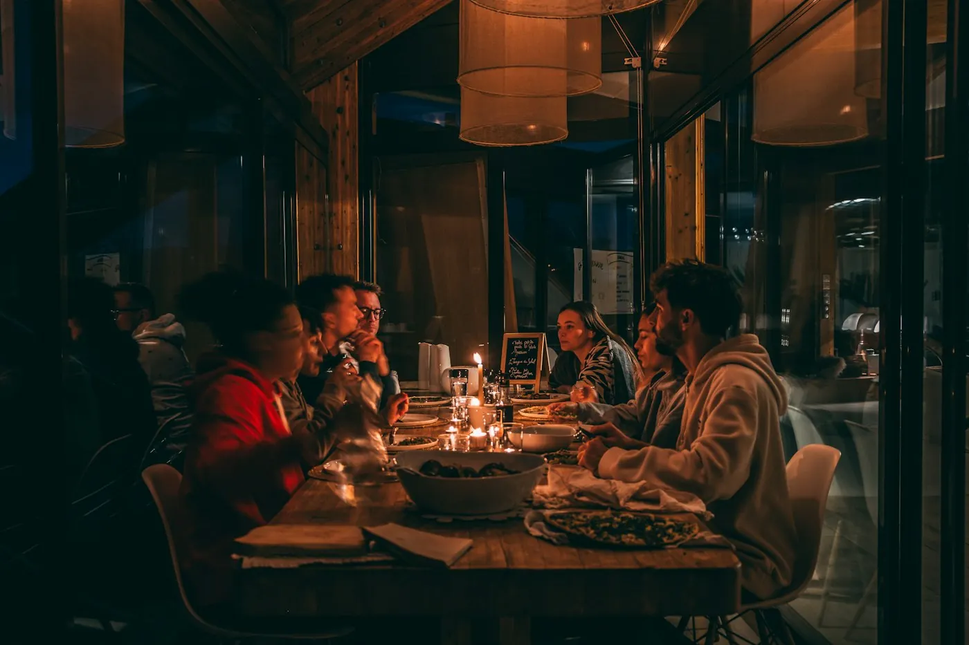Friends sharing dinner by candlelight
