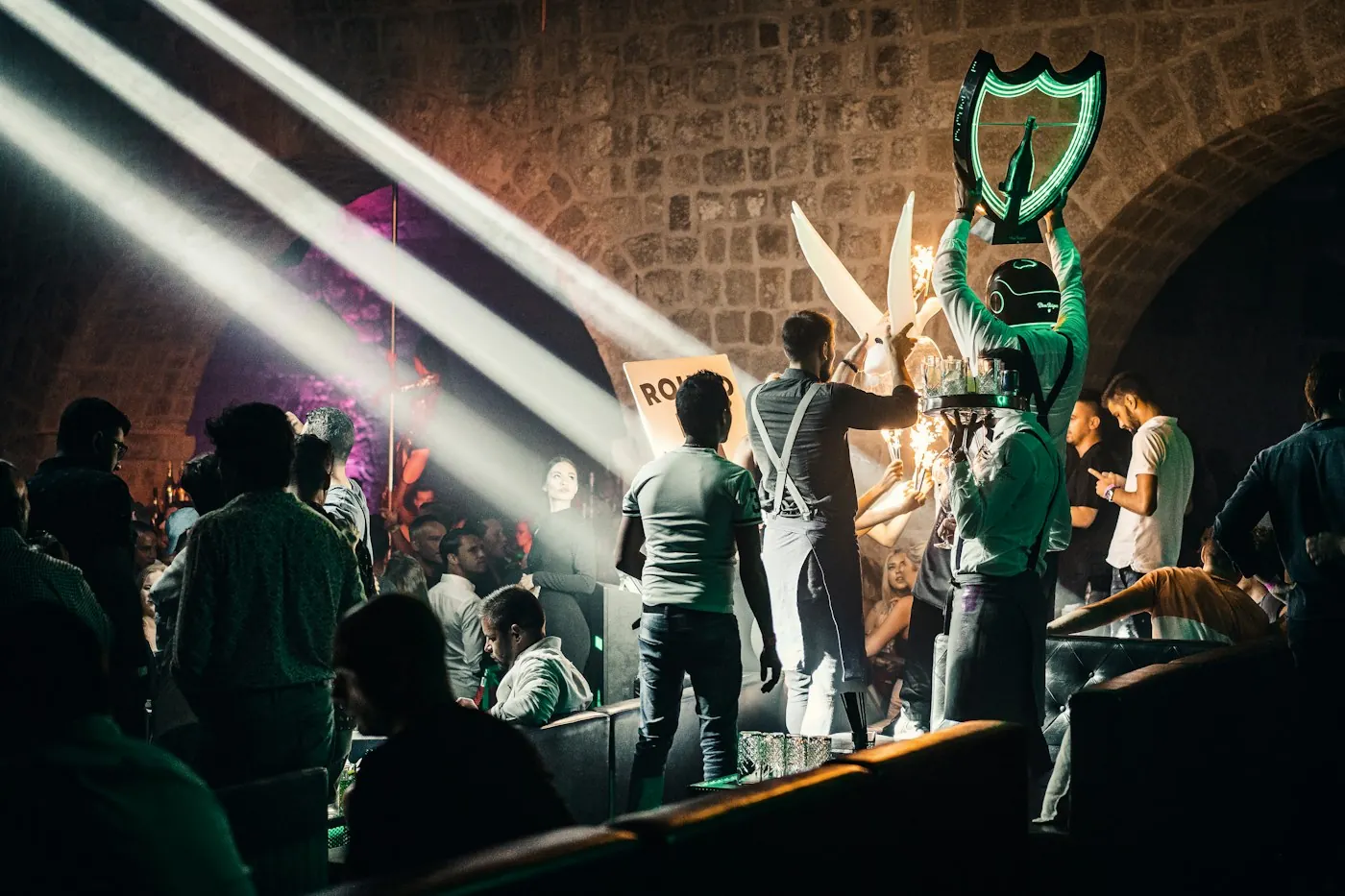 Guests and staff around a nightclub table